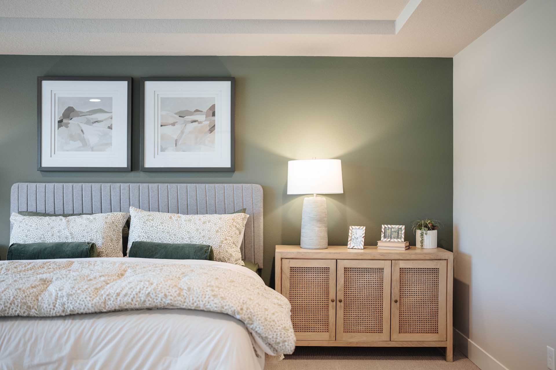 Bedroom with a green wall and a neutral color wood bedside table