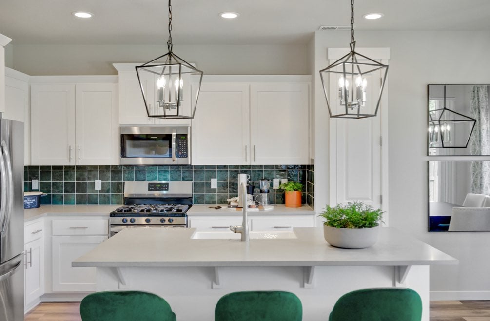 Modern kitchen with green tile and emerald stools
